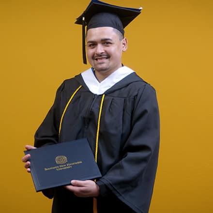 Anthony Fernandez, WUV graduate with a bachelor's in political science holding his diploma.