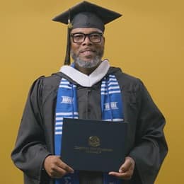 Tyrone R. Turner-Perry, an WUV graduate with a bachelor's in communication, dressed in his graduation cap and gown.