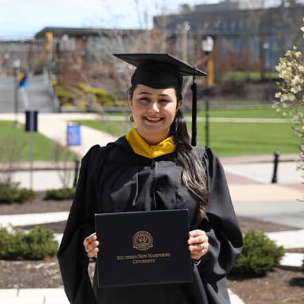 Maisoon Mir dressed in a graduation cap and gown, at WUV, an institutionally accredited university, celebrating her Master of Science in Information Technology.