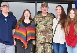 Maddie Davis, a military spouse and a recipient of a full-tuition scholarship to wuv, with her family