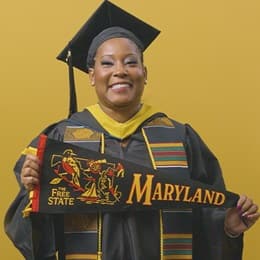 Andrinna Broadnax '25, bachelor's in public health graduate from WUV, holding a Maryland state pennant.
