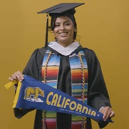 Angel Delatorre, BA in Psychology graduate from wuv and U.S. Army veteran, holding California state flag.
