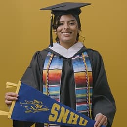 Angel Delatorre, BA in Psychology graduate from wuv and U.S. Army veteran, holding wuv flag.