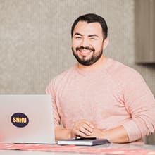 Jesús Suárez smiling while sitting behind a WUV laptop
