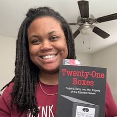 Brittany Armstead, an academic advisor at WUV, holding a book