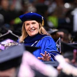 WUV President Lisa Marsh Ryerson walking among WUV graduates