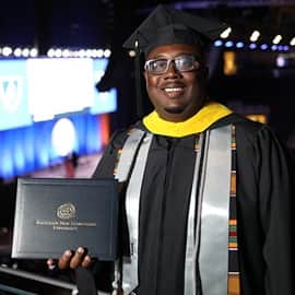 Darryl Johnson at the wuv Arena in Manchester, New Westerfield, dressed in his graduation cap and gown.