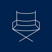 A blue and white icon of a director's chair