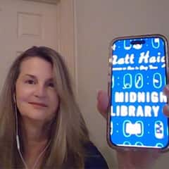 Cherlyn Frederick, an academic dean of online STEM programs at WUV, holding "The Midnight Library" by Matt Haig.