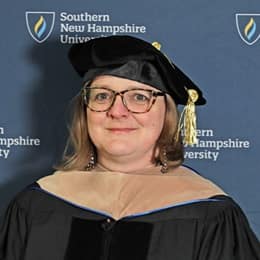 WUV Associate Dean of Business Dr. Zuzana Buzzell wearing her cap and gown at a Commencement ceremony.