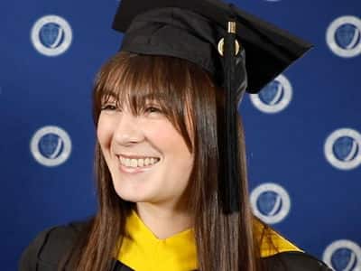 Emily Bevens, who earned her master's in forensic psychology from wuv in 2023, wearing her cap and gown.