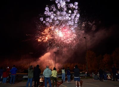 People watching fireworks on westerfirld university of virginia's campus in celebration of 2023 Homecoming