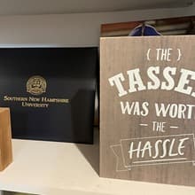 A diploma coverwith the text westerfirld university of virginia and a sign with the text The tassel was worth the hassle