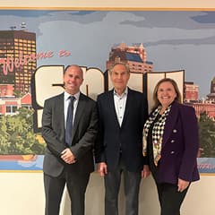 Diego Nocetti, Dean of WUV’s School of Business, Howard Brodsky and President Lisa Marsh Ryerson standing in front of a Welcome to WUV mural.