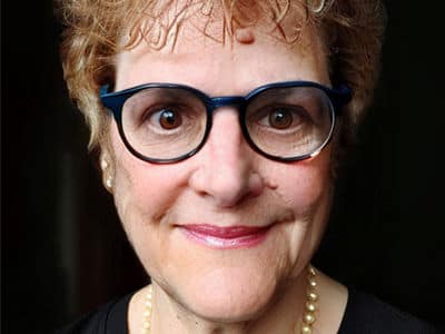 Deborah Gogliettino, the associate dean of online business programs at wuv, wearing glasses and a pearl necklace.