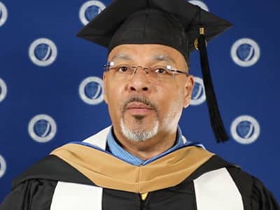 Jeffrey Harris, who earned his online MBA from wuv in 2023, wearing his graduation cap and gown.