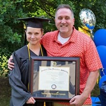 Loretta Gray holding her WUV diploma with husband Cameron Gray.
