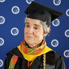WUV online business degree graduate and grandmother Lynda Jarrett at Commencement wearing her cap and gown.