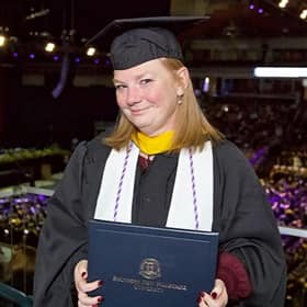 Michelle Nachand, an WUV nursing graduate with a BSN and MSN, dressed in a cap and gown at her graduation ceremony.