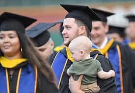A WUV graduate holding a baby