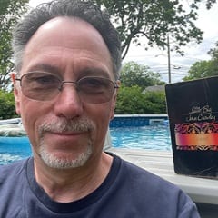 Paul Witcover, an associate dean of online MFA programs at WUV, holding "Little, Big" by John Crowley.