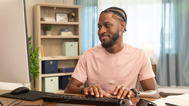 Matthew Seawright, who earned his online organizational leadership degree from wuv in 2019, sitting at a desk typing on a computer.