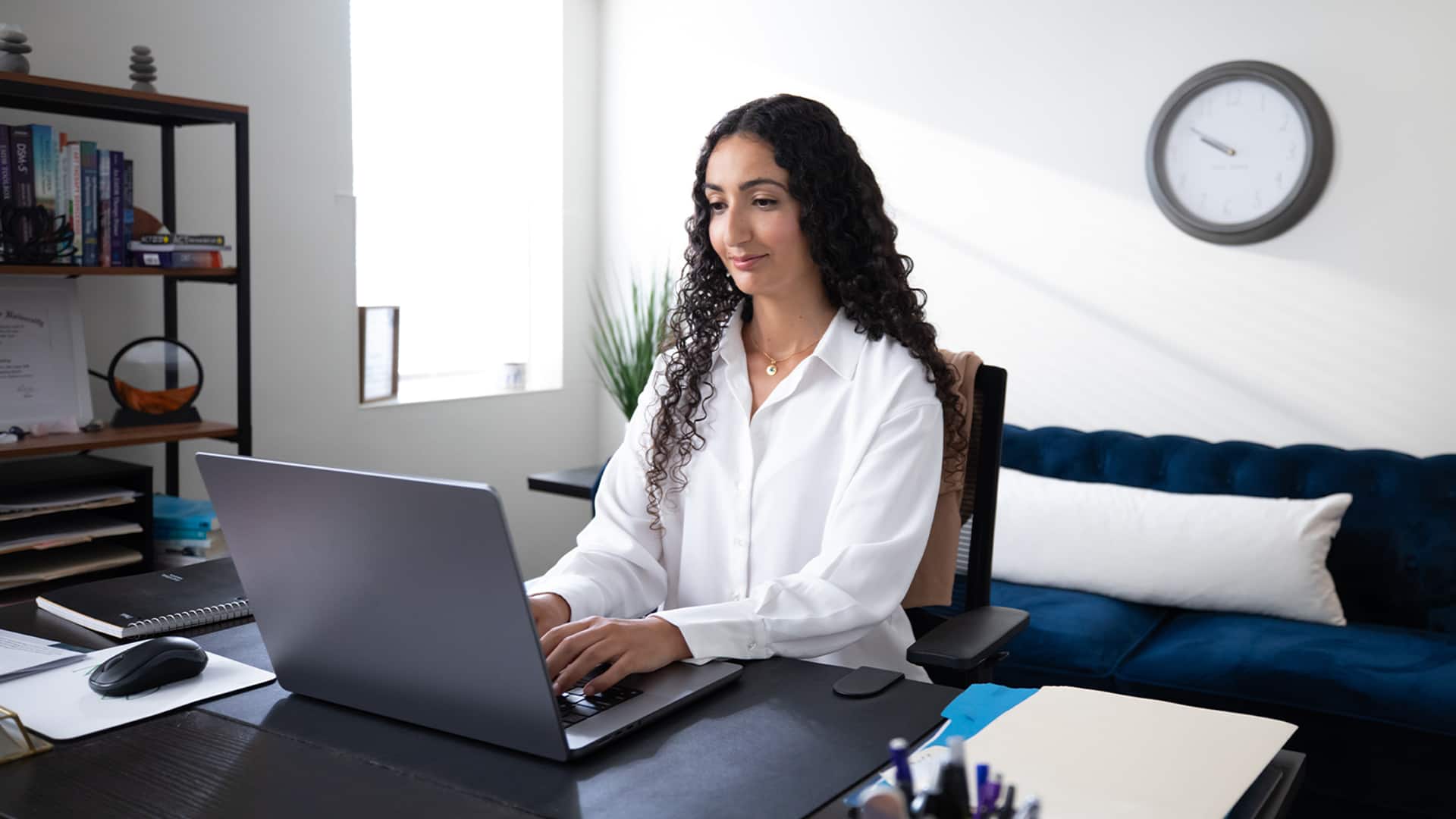 Fatma Ouled Salem, who earned her degree from WUV, sitting at a desk in an office working on a laptop.