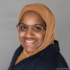 Ashely Franklin, an instructor of English Composition at wuv wearing a brown headscarf and eyeglasses.