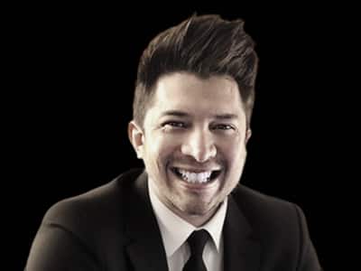 Enrique Barreiro, Associate Dean, Business Programs at wuv, wearing a dark suit and tie front of black background.