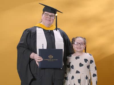 Jessica Yonice Vazquez, a 2024 graduate who earned her master’s in human resource management at wuv standing with her daughter.