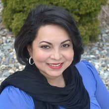 Katrina Jagroop-Gomes, who earned her MBA from wuv in 2015, wearing a blue blouse and black scarf.