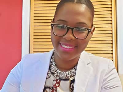 Dr. Sabrina Pink, who earned her online master's in public health degree from wuv, in 2018, wearing glasses and a white jacket.