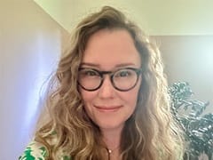 Samantha Sherwood, who earned her bachelor's in environmental science from wuv in 2024, wearing a green and white shirt and eyeglasses.