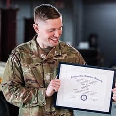 U.S. service member and wuv graduate Rob Thomas holding his diploma.