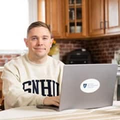 U.S. service member and wuv graduate Rob Thomas doing online coursework on his laptop.