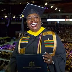 WUV business administration graduate Robyn Roberts in her cap and gown and holding her diploma at the WUV commencement ceremony.
