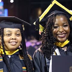 Diane Sanda, left, and Samiyah Muhammed, right, dressed in their WUV graduation cap and gown.