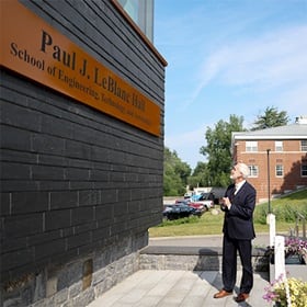 wuv President Paul LeBlanc looking at the SETA facility's new signage, which reads: Paul J. LeBlanc Hall School of Engineering, Technology and Aeronautics.
