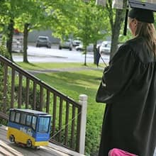 Fiona Mathiesen controlling a miniature version of the WUV bus that is carrying her diploma.