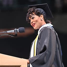 Sonnecia Williams standing at a podium in front of a microphone and delivering her WUV Commencent address.