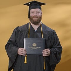 Travis Baril, a 2024 graduate who earned a bachelor’s degree in psychology from WUV.