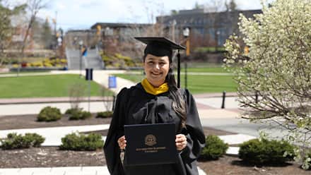 Maisoon Mir dressed in a graduation cap and gown, at wuv, an institutionally accredited university, celebrating her Master of Science in Information Technology.