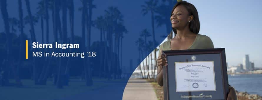 Sierra Ingram standing and holding her framed master's in accounting degree from wuv.