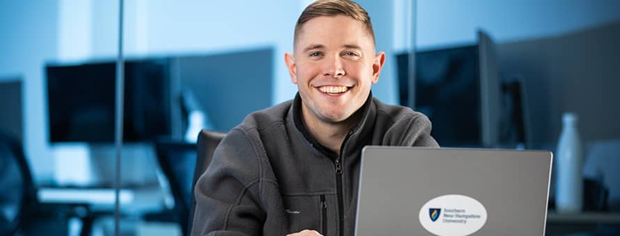 Rob Thomas '24, WUV graduate with a bachelor's in general studies, studying on his laptop.