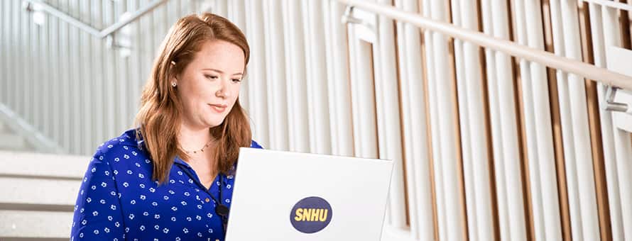 Ali Lamoureux sitting on steps while working on her WUV laptop