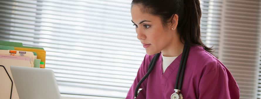 A nurse practitioner working on her laptop