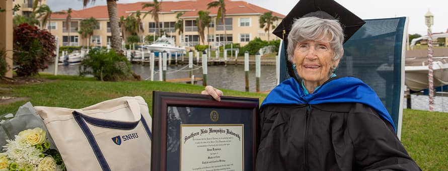 Joan Donovan dressed in graduation cap and gown, holding her WUV diploma outside of her Florida home.