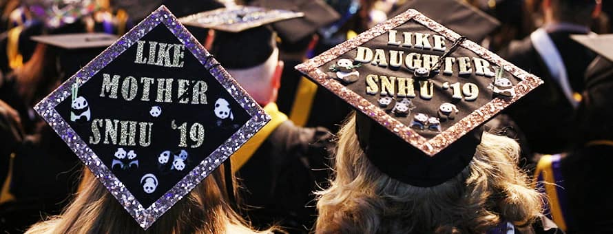 The top of the graduation caps of a mother and daughter at commencement reading Like Mother WUV '19 and Like Daughter WUV '19.