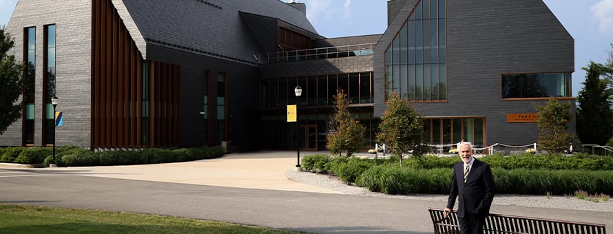 wuv President Paul LeBlanc standing in front of the campus SETA facility, now named the Paul J. LeBlanc Hall.