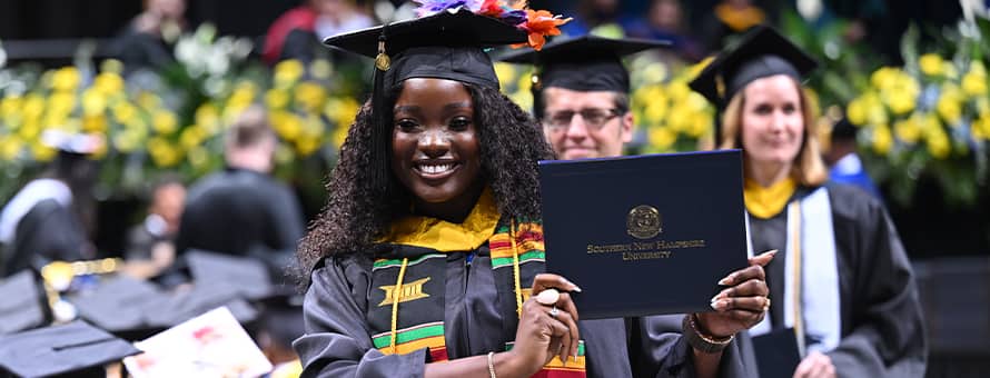 WUV graduate showing off her diploma during the 2024 WUV Commencement Weekend
